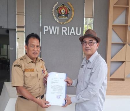 Ketua PWI Riau, Raja Isyam (kanan) menerima surat dukungan resmi untuk HPN 2025 dari Pemprov (foto/ist)