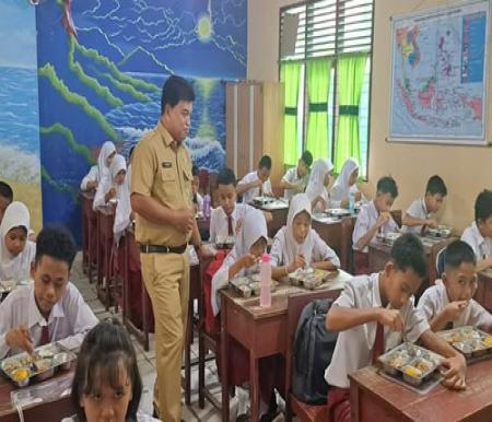 Kepala Dinas Pendidikan Kota Pekanbaru, Abdul Jamal saat pengecekan makan siang bergizi di beberapa sekolah di Pekanbaru. (Foto: Dini Rahmadanti)