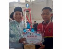 Kepala Bakesbangpol Rohil, Cicik Mawardi Athar menyerahkan hadiah kepada salah satu pemenang LKBB Duta Pancasila (foto/afrizal)
