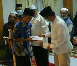 Penyerahan santunan kepada anak yatim.