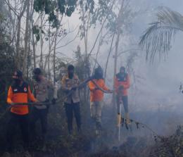 Bupati Kepulauan Meranti H Muhammad Adil bersama Kapolres, AKBP Andi Yul Lapawesean Tendri Guling SIk MH saat memadamkan api di Desa Bokor