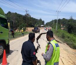 Personel polisi melakukan pengecekan jalan amblas di Kecamatan XIII Koto Kampar. 