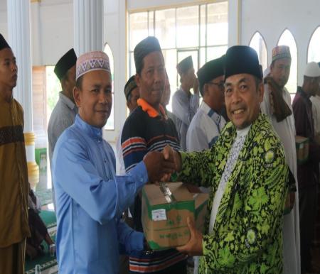 Ketua PD DMI Rohil, Wazirwan Yunus menyerahkan bantuan alat kebersihan si masjid/musaha Kecamatan Rimba Melintang (foto/Afrizal)