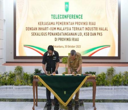 Gubernur Riau, Syamsuar dan Wakil Dekan INHART International Islamic University Malaysia, Faizur saat penandatanganan LOI.(foto: mcr)