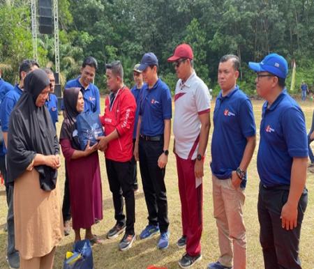 Bupati Pelalawan, Zukri didampingi COO RAPP Eduward Ginting menyerahkan bantuan paket sembako ke salah satu warga Desa Delik, dalam rangka RGE Founder